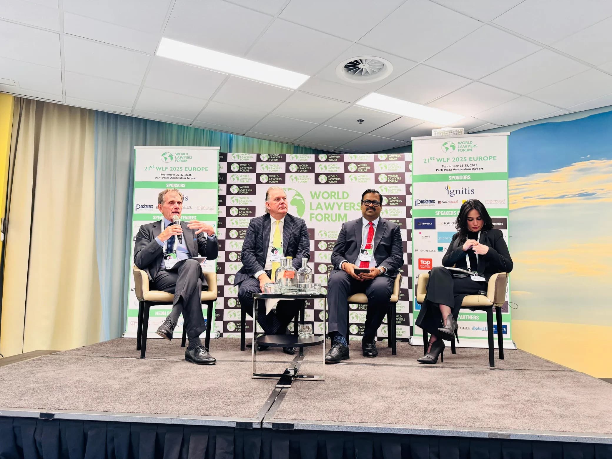 Speakers in conversation in front of WLF branding at Europe 2025